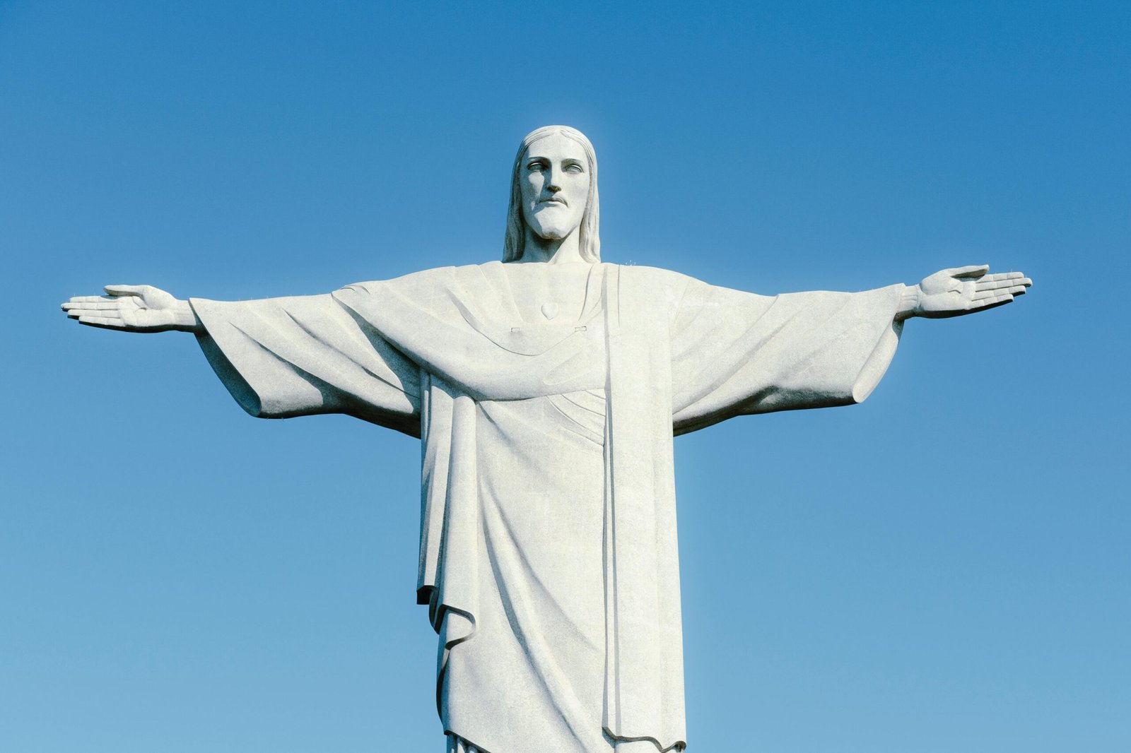 Iconic Christ the Redeemer statue in Rio de Janeiro, Brazil, with a clear blue sky background.